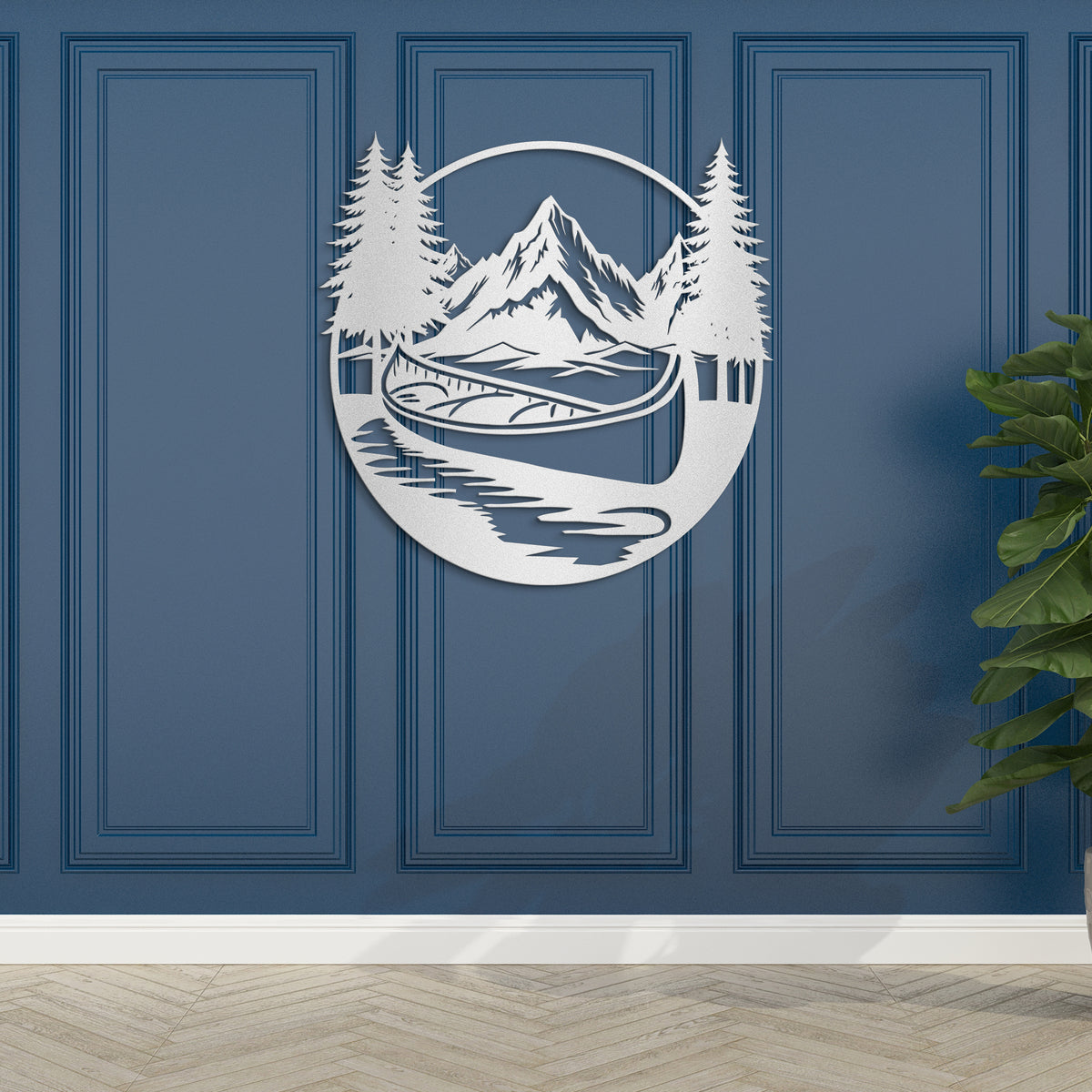 Silver mountain and forest metal wall art with a lake scene displayed on a blue paneled wall