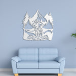 White mountain bike metal wall art with pine trees and mountains displayed above a light blue sofa